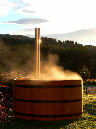 A Lignum Hot Tub giving off steam whilst running in a beautiful morning scenery.