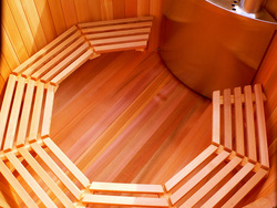 The cedar inside of a Deluxe Lignum Hot Tub, with benches or seats and a TubSub wood fired heater.